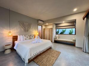 a bedroom with a large bed and a window at Kalia Bingin - Adult only in Uluwatu