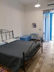 a bedroom with a bed and a table and a chair at "la casa dell'architetto" con terrazza panoramica in centro storico e a due passi dal porto in Lipari