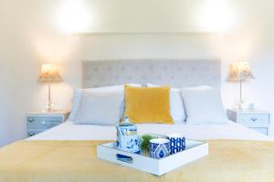 ein Schlafzimmer mit einem weißen Bett und einem Tablett darauf in der Unterkunft Villa El Castañal con Piscina Privada in Vigo