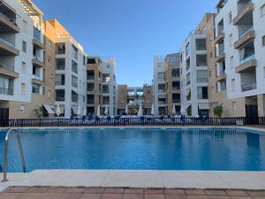 uma piscina no meio de dois edifícios de apartamentos em Espectacular Atico Frente Al Mar em Isla del Moral