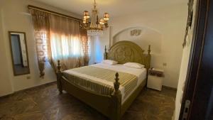 a bedroom with a large bed with a chandelier at Royal stylish view apartment in Koropíon