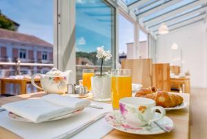einen Tisch mit Tassen und Teller mit Speisen und Orangensaft in der Unterkunft ART HOTEL HOUSE ONE in Baden-Baden