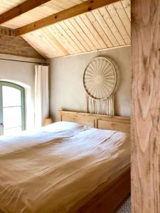 een slaapkamer met een groot bed en een houten plafond bij Thomashof Klein-Mutz in Zehdenick