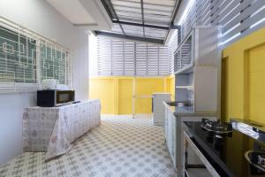 a large kitchen with yellow and white at Basic Line Villa เบสิค ไลน์ วิลล่า in Chiang Mai
