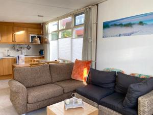 una sala de estar con un sofá y una mesa en Op 't Landtweg 37a, en Callantsoog