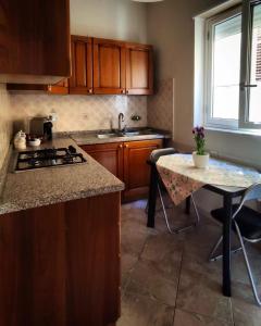 a kitchen with a stove and a table with chairs at La Margherita - Casa vacanze in Montallegro