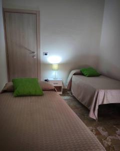 Habitación con 2 camas con almohadas verdes. en La Margherita - Casa vacanze, en Montallegro