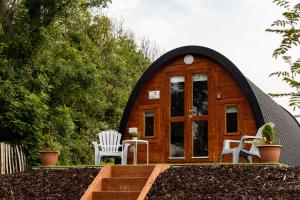 una pequeña casa en la cúpula con 2 sillas y una mesa en Ivy hill Glamping Pod, en Ennis