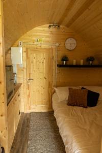Bett in einem Zimmer mit einer Uhr an der Wand in der Unterkunft Ivy hill Glamping Pod in Ennis