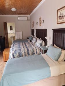 a bedroom with two beds and a table at Skietberg Lodge in Colesberg +41 photos