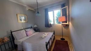 ein Schlafzimmer mit einem Bett mit zwei ausgestopften Tieren darauf in der Unterkunft Alex Apartment in Perama