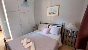1 dormitorio con 1 cama con almohadas rosas y blancas en Alex Apartment, en Perama