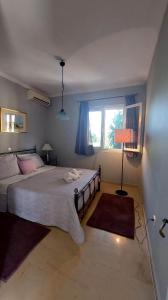 ein Schlafzimmer mit einem großen Bett und einem Fenster in der Unterkunft Alex Apartment in Perama