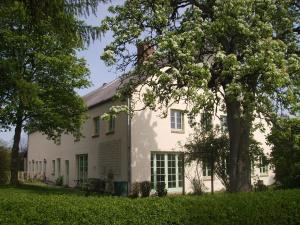 uma casa branca com uma árvore em frente em Hof Rodenkrog em Lütjenburg