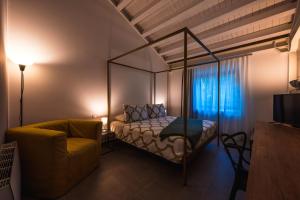 a bedroom with a canopy bed and a chair at Vulcano SudEst in Santa Venerina