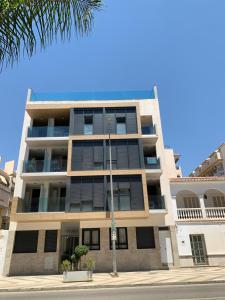 モルシェにあるApartamento NEPTUNO con piscina a 50 mt de la playaのヤシの木のある通りに建つアパートメント