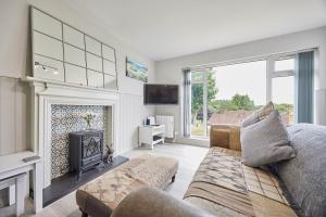 uma sala de estar com um sofá e uma lareira em Host & Stay - Robin's Nest em Gunnislake