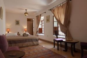 una camera con un letto e una sedia e una finestra di Dar Warda a Marrakech