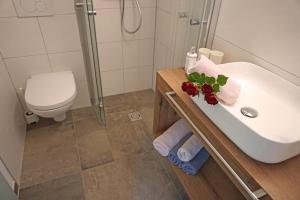 Un baño con lavabo, inodoro y ducha. en St. Lukas Apartments, en See 16 fotos más