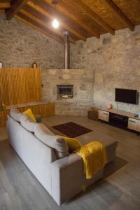 ein Wohnzimmer mit einem Sofa und einem Kamin in der Unterkunft DreamVille - Casa da Tapada in Arcos de Valdevez