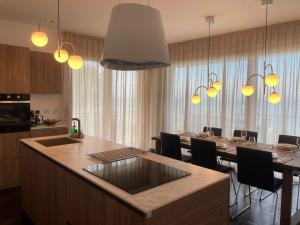 a kitchen and dining room with a table and chandeliers at Bardolino Luxury in Bardolino