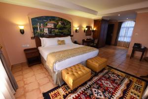 a bedroom with a large bed with a painting on the wall at Casa Solada Hotel in Kampala