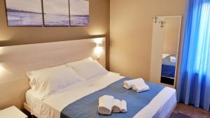 a bedroom with a bed with two towels on it at Pianomare Riviera Apartments and Rooms in Imperia