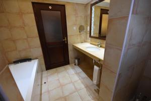 a bathroom with a sink and a toilet and a mirror at Casa Solada Hotel in Kampala