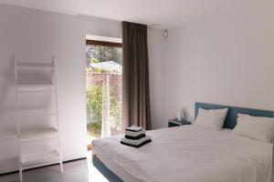 een slaapkamer met een wit bed en een raam bij HUIS19 Luxury apartments in Gent