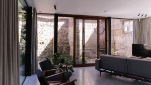 a living room with a couch and a tv at HUIS19 Luxury apartments in Ghent