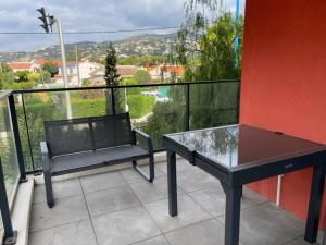 a table and bench on a balcony with a view at RIVIERA COTTAGE in Mandelieu-La Napoule