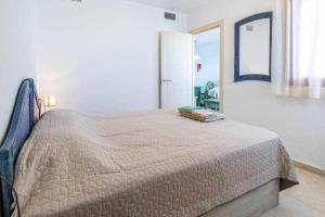 sypialnia z łóżkiem w białym pokoju w obiekcie Inftour Amatista 9 Apartamento w mieście Calpe