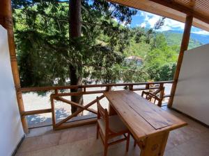 a wooden table and chairs on a balcony with a view at SÜMELA HOLİDAY HOTEL in Macka