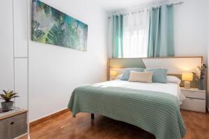 Vivienda con Fínes Turísticos "Valdivia" في أندوخار: غرفة نوم بسرير وبطانية خضراء