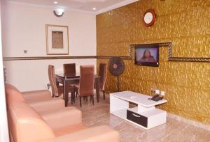 a dining room with a table and a clock on a wall at Immaculate 2-Bed Apartment in Idimu in Idimu