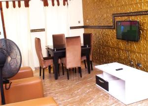 a living room with a table and chairs and a television at Immaculate 2-Bed Apartment in Idimu in Idimu
