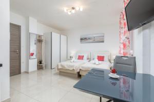 プーラにあるMarine Lux apartmentsの部屋にベッドとテーブルがある寝室