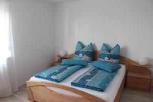 a bedroom with a bed with blue pillows on it at Ferienwohnung Felgenwald in Michelstadt