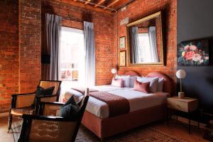 a bedroom with a bed and a brick wall at Old Foundry Hotel in Cape Town