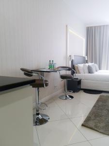 salon z łóżkiem, stołem i krzesłami w obiekcie Softly Residence w Bydgoszczy