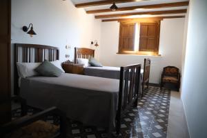 a bedroom with two beds and a window at Casa Bécquer in Noviercas