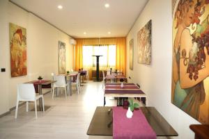 a restaurant with tables and chairs and paintings on the walls at Domus Salentina in Leverano