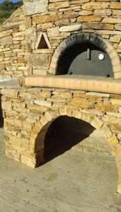 a stone oven with a brick wall with a window at Villa Elia Ios in Ios Chora