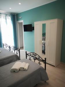 a bedroom with two beds and a television on the wall at Elipa in Mandra Capreria