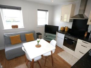 ein Wohnzimmer mit einem weißen Tisch und eine Küche in der Unterkunft Turay Court Holiday Apartments in Bournemouth