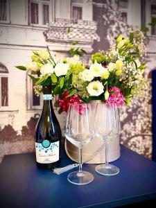 a bottle of wine and two glasses on a table with flowers at ZAMEK NA PIASKU in Chłopy