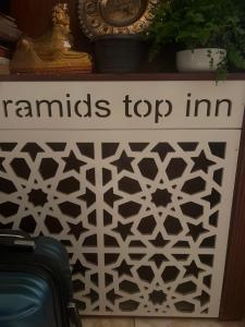 a sign that reads tunnels top inn next to suitcases at Pyramids Top Inn in Cairo