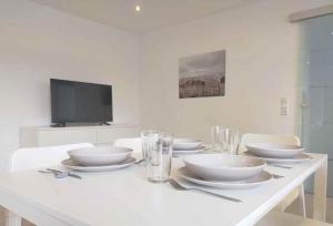 un tavolo bianco con ciotole bianche e bicchieri di Cozy & Modern 4 Room Flat near Hanau a Gedern