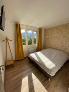 Un dormitorio con una cama grande y una ventana en Les Balcons de la Vallée en Haybes