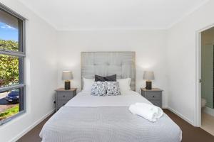 a bedroom with a large white bed with two lamps at 134 North Perth Nest For 4 Parking in Perth